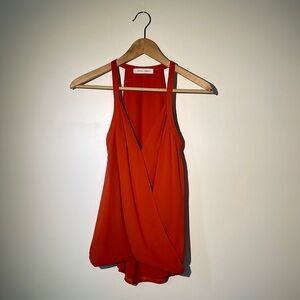 olivia + james sleeveless top. Orange crossover front with rounded back hem.